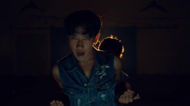 Gece boyunca atmosferik ışık ve toz parçacıklarının havada olduğu bir odada dans eden bir grup insan.