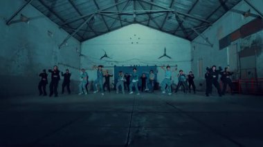 Bir grup insan loş bir odada dans ediyor, hareket bulanıklığı, gece boyunca neşe ve hareket ifade ediyor.