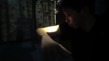 Koyu bir arkaplanda kısmen görünür bir kolun olduğu loş bir sahne. Odaklanma kolda, gölgeler gizemli bir atmosfer yaratıyor..