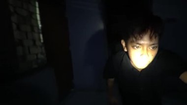 Karanlık bir ortamda fener tutan bir insan, çevresini aydınlatır. Sahne, duvarlarda gölgelerin oynadığı bir gizem ve keşif hissi veriyor..