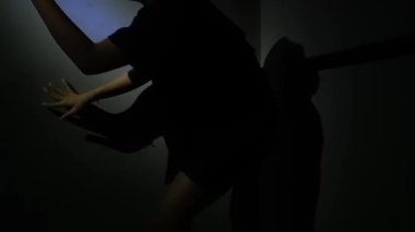 Yüzüne doğru uzanan bir elin karanlık silueti gizemli ve samimi bir atmosfer yaratıyor..