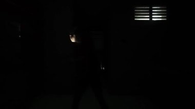 Karanlık bir ortamda, yumuşak pembe bir ışıkla aydınlatılmış loş bir sahne. Bu figür bir aktiviteye katılmış gibi görünüyor, muhtemelen tırmanıyor ya da gölgelerle çevrili..