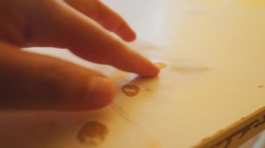 Muhtemelen bardaklar ya da parmak izlerinden oluşan beyaz bir yüzeye uzanan bir elin yakın çekimi, gelişigüzel ya da sanatsal bir ayarı işaret ediyor..