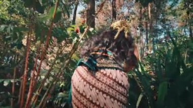 Geleneksel Java batiği ve başlık takan iki kadının, güneşin ıslattığı güzel bir ormanda yürürken el ele tutuşurken çekilmiş bir fotoğrafı. Bu klip bir yolculuk, dostluk ve kültür mirasını çağrıştırıyor..