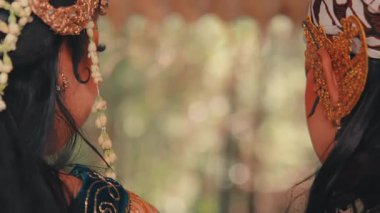 Geleneksel bir Cava çifti için samimi bir profil çekimi. Özenle hazırlanmış makyaj ve kostümlerle süslenip birbirlerine sevgiyle gülümsüyorlar. Kültür, düğün ve romantik temalar için mükemmel.