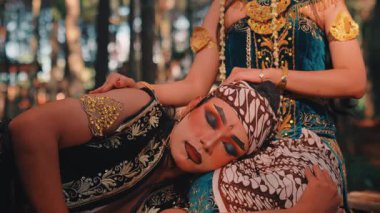 Rama 'yı canlandıran bir adam başını bir kadının kucağında Sinta olarak dinlendiriyor. Orman ortamında onu nazikçe okşuyor. Bu geniş açı dramatik duyguları, güzel kostümleri ve sahnenin doğal manzarasını yakalar..