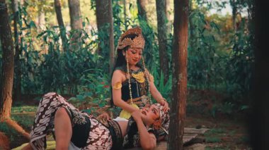 Mitolojik karakter Rama 'yı canlandıran bir adam, başı ortağı Sinta' nın kucağında, ormandaki ahşap bir platformda yatıyor. Aşk ve folklorun güzel bir sahnesinde ona şefkatle bakıyor..