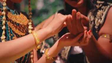 Geleneksel giyinmiş bir Cavalı çiftin ellerine odaklanan samimi bir yakın çekim. Birbirlerine nazikçe dokunurlar, yüzlerini göstermeden önce güzel kostümlerini ve altın mücevherlerini gösterirler..