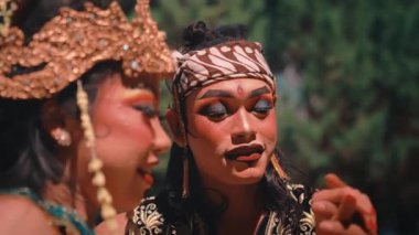 Geleneksel Cava kıyafetleri içinde mutlu bir Endonezyalı çiftin yakın çekimi. Kadının elini tutan ve yüzüne dokunan adamla şakalaşıp gülüyorlar. Büyüleyici ve romantik bir an yaratıyorlar..