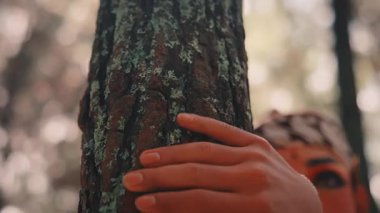 Sırtında dramatik makyajı ve okları olan erkek bir Cava okçusunun yakın plan portresi. Güneşli bir ormanda bir ağaca yaslanırken dikkatlice yukarı bakar, Endonezya mitolojisinden bir kahramanı somutlaştırır..