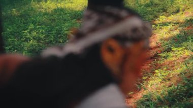 Omzundan vurulan bir kurşun geleneksel bir Cava okçusunu takip eder ve güneş lekeli bir ormana bakar. Sırtına ve kafasına odaklanmak bir gizem, gözlem ve beklenti hissi yaratıyor..