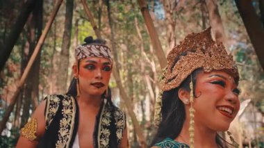 Güzel, süslü kostümlü bir kadın ve bir Cava erkeği bambularla çevrili bir ormanda yan yana duruyorlar. Etrafa dramatik ifadelerle bakınıyorlar, geleneksel Endonezya hikayesinden bir sahne canlandırıyorlar..