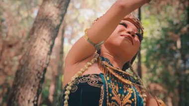 Cava dansçısının üst vücut hareketlerinin düşük açılı yakın çekimi. Yasemin çiçekleriyle dokunmuş karmaşık bir başlığı ortaya çıkarmak için dönmeden önce nazikçe kollarını kaldırır..