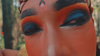 Büyüleyici bir makro çekim, geleneksel bir Cava okçusunun dramatik göz makyajına odaklanır. Geri çekilmeden önce güzel bir orman ortamında gururla ayakta duran tüm karakteri gözler önüne serer..