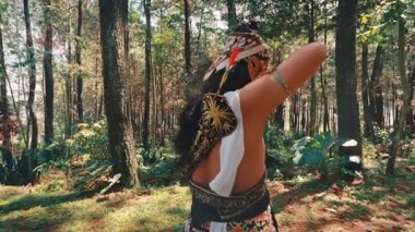 Arkadan bakıldığında, geleneksel bir Java okçusu güneşli bir ormanda gökyüzüne bakıyor. Geniş, alçak açılı çekim, doğayla olan huzur, yalnızlık ve ruhsal bağlantıyı vurguluyor..