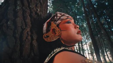 Acı ve iç karışıklığı gösteren Cava 'lı bir erkek dansçının yakın plan, dramatik performansı. Bir ağaca yaslanır, anlamlı yüzü ve hareketleri derin bir keder ya da ıstırabın hikayesini anlatır..