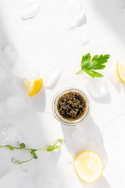 おいしいデリカテッセンの前菜 天然のチョウザメ黒キャビア レモンスライス アイスキューブのパセリ 選択的焦点 — ストック写真