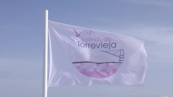 位于西班牙科斯塔布兰卡的托雷维贾盐湖的萨利纳斯 托雷维贾号 Salinas Torrevieja Salt Lake Torrevieja 的闭塞旗缓慢地在风中飘扬 慢镜头 — 图库视频影像