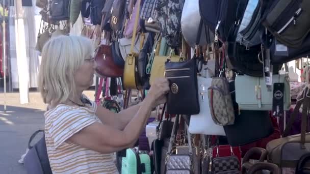 Blondynka Okularach Przeglądająca Torebki Sprawdzająca Zamki Lokalnym Rynku Torrevieja Hiszpania — Wideo stockowe