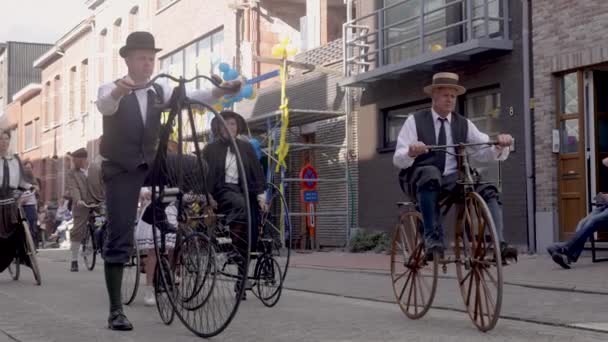 アントワープの地元のストリートフェアで伝統的な服を着て古い時代のヴィンテージ自転車に乗っている男性 スローモーションビデオでWilrijkgeitenstoetと呼ばれる — ストック動画