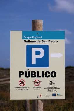 closeup of Publico or Public parking sign at the salt lakes or Salinas de San Pedro. No drones, no overnight parking and dogs on lead