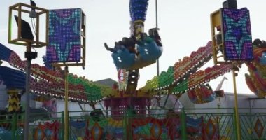 Carnival ride at fair in Lier, People enjoying amusement rides in slow motion footage