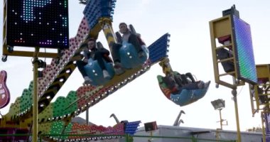 People enjoying amusement rides in slow motion footage