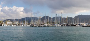 İspanya, Cartagena Limanı 'nda arka planda dağlar ve dramatik gökyüzü olan yelkenli manzarası