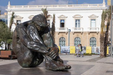 İspanyol heykeltıraş Victor Ochoa 'nın Cartagena' da El Zulo adlı dizlerinin arasına gömülü bir adamın dramatik bronz heykeli.