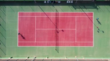 Tanınamayan tenis oyuncularıyla kırmızı kil tenis kortunun havadan aşağı görüntüsü