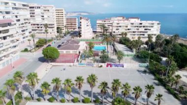 Palmiye ağaçları, spor sahaları ve Cabo Cervera, Torrevieja ve La Mata plajlarındaki apartmanlara taşınan insansız hava aracı.