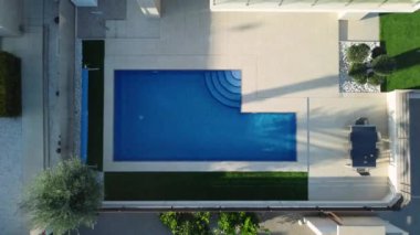 İnsansız hava aracı havuzda sudan yükseliyor ve Torrevieja yakınlarındaki Vistabella golf sahasında konut ve emlak geliştirme alanındaki villaları gösteriyor.