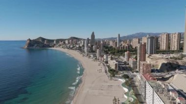Popüler Benidorm plaj tatilinin ve turkuaz deniz suyu ve gökdelenleri gösteren gezinti güvertesinin insansız hava aracı statik görüntüsü