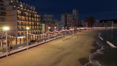 Geceleri Benidorm sahilinin havadan görünüşü. Gezinti güvertesinde ışıklar ve yanan plaj
