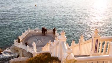 Turistler Benidorm izleme platformunun deniz manzarasının tadını çıkarıyorlar. Balco del Mediterrani adlı güzel altın öğleden sonra ışığında.