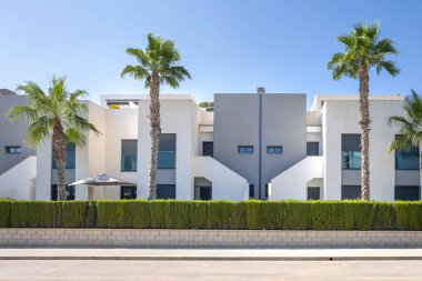 İspanya 'da modern dairelerin önünde şemsiye ve palmiye ağaçları