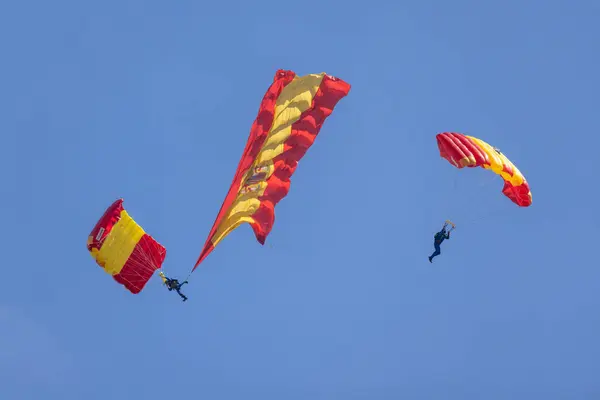 stock image Acrobatic parachutist at the 2024 San Javier air show with a big Spanish national flag falling from the sky