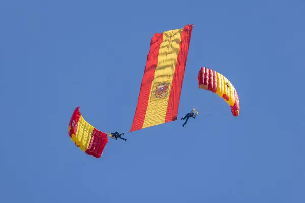 stock image Parachutist at the 2024 San Javier air show with a big unfolded Spanish national flag falling from the sky and leaving smoke trail