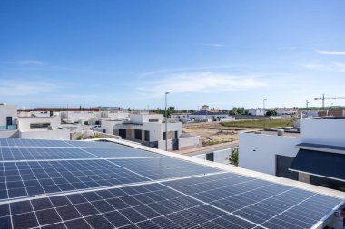 İspanya 'nın Daya Nueva kentindeki modern evlerdeki güneş panellerinin çatısı, açık mavi gökyüzü ve gelişmekte olan yerleşim alanı..