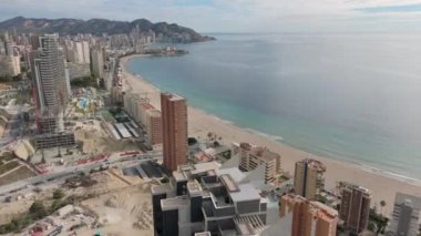 İnsansız hava aracı Benidorm gökdeleninin üzerinden uçarken çekildi, Platja de Ponent plajı, yakındaki plajlar ve sakin Akdeniz sularıyla şehrin kıyı silueti gözler önüne serildi.