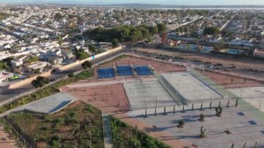 İHA, La Siesta Park, Torrevieja 'daki spor sahalarında yavaşça uçuyor. Padel kortları, oyun alanlarını ve kentsel çevreyi vurguluyor..