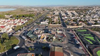 İHA, La Siesta Park, Torrevieja 'daki spor sahalarında yavaşça uçuyor. Padel kortları, oyun alanlarını ve kentsel çevreyi vurguluyor..