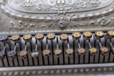 Süslü bir antika kasadaki numaralandırılmış anahtarların ayrıntılı görünümü, karmaşık metal işleri ve retro tasarım elementlerini sergiliyor.