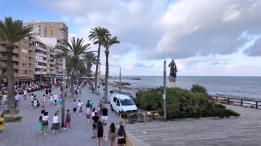 Palmiye ağaçları ve insanlarla dolu, manzaralı okyanus manzaraları sunan, ve bir yaz öğleden sonra rahat bir atmosfer sunan, hareketli bir sahil geçidi.