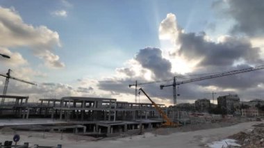 Torrevieja 'da yeni dairelerin inşaatı devam ediyor. Gün batımında dramatik bir gökyüzüne karşı vinçlerle yakalandılar..