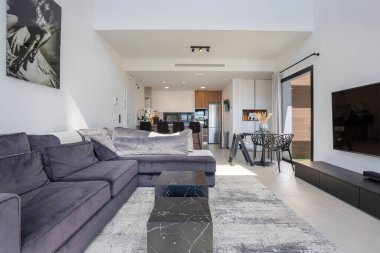 Parlak yaşam alanı, modern bölümsel, mermer tarzı masalar ve doğrudan mutfak erişimi..