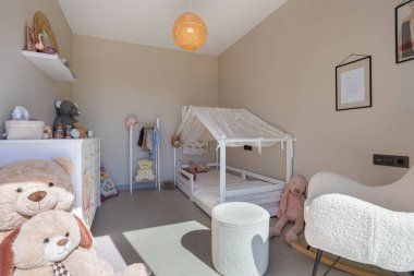 Hoş çocukların yatak odasında rahat bir ev çerçevesi ve pelüş oyuncaklar var..