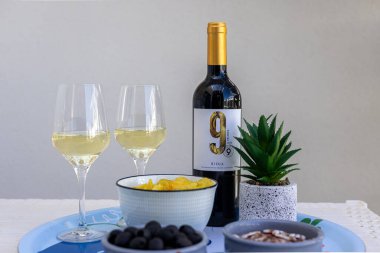 Şarap, abur cubur ve teras merdiveninin altında yumuşak gün ışığında biraz sulu masa üstü kompozisyonu..