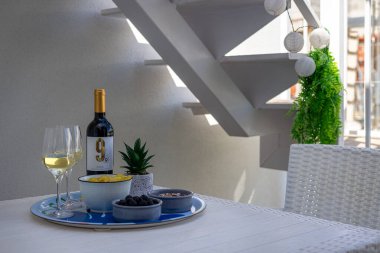 Şarap kadehleri, bir şişe Rioja, zeytin ve abur cubur ile beyaz bir masaya yakın çekim yapmak, rahat bir açık hava havası yaratır..