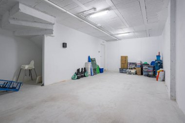 Çok amaçlı yeraltı depolama alanı, ekipman, kutular ve spor malzemeleri düzgünce düzenlenmiş..